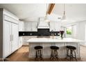 Bright modern kitchen features white cabinets, stainless steel appliances, an island with counter seating, and hardwood floors at 4125 N 64Th St, Scottsdale, AZ 85251