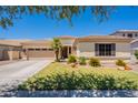 Charming single-story home featuring a well-manicured lawn, desert landscaping, and a spacious two-car garage at 4235 S Snowcap Dr, Gilbert, AZ 85297