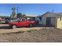 Red truck in driveway of home with boarded up windows and missing siding at 4304 N 55Th Dr, Phoenix, AZ 85031