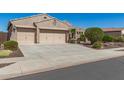 Charming home featuring a three car garage with neutral toned doors and desert landscaping in the front yard at 5107 N 194Th Dr, Litchfield Park, AZ 85340