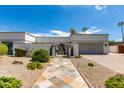 Eye-level view of a single-story home featuring desert landscaping and decorative iron gate at 8219 N 3Rd Ave, Phoenix, AZ 85021