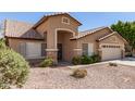 A tan single-story home with a desert rock yard and a tile roof at 8343 W Paradise Dr, Peoria, AZ 85345