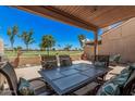Relaxing covered patio with golf course views, stylish patio furniture and a ceiling fan at 10124 E Michigan Ave, Sun Lakes, AZ 85248