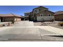 Two-story home with a long driveway is framed by desert landscaping and rock at 10347 W Odeum Ln, Tolleson, AZ 85353