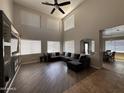 Bright living room features a soaring ceiling, large windows, and stylish decor at 10347 W Odeum Ln, Tolleson, AZ 85353