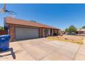 Brick exterior home features a basketball hoop and large driveway at 1123 W Mendoza Ave, Mesa, AZ 85210