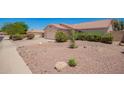 Inviting single-Gathering home featuring desert landscaping and a two-car garage, creating a warm and welcoming curb appeal at 11352 E Dartmouth St, Mesa, AZ 85207