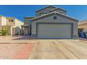 Two-story home with a two-car garage, neutral tones, desert landscaping, and mature landscaping at 12325 W Dreyfus Dr, El Mirage, AZ 85335