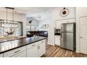 Well-lit kitchen featuring stainless steel appliances, white cabinetry, and an island with dark countertops at 1397 E Laurel Pl, Casa Grande, AZ 85122
