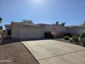 A single story home featuring a stucco exterior, a two car garage, and a large concrete driveway at 14214 N Galatea Dr # A, Fountain Hills, AZ 85268