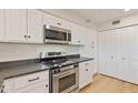 Well-lit kitchen with stainless steel appliances, white cabinetry, and dark countertops at 154 W 5Th St # 246, Tempe, AZ 85281