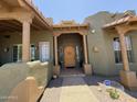 Welcoming front entrance with a custom wooden door at 15523 W Peakview Rd, Surprise, AZ 85387