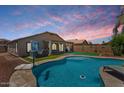 Gorgeous backyard with a pool, putting green, and covered patio, perfect for outdoor living and entertaining at 1564 E Leaf Rd, San Tan Valley, AZ 85140