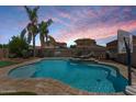 Resort-style pool with a waterfall feature, lush landscaping, and plenty of space for entertaining in the backyard at 1564 E Leaf Rd, San Tan Valley, AZ 85140