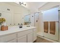 Bright bathroom with a glass-enclosed shower, a neutral vanity, and wood-look floors at 16586 W Latham St, Goodyear, AZ 85338