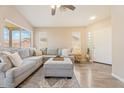 Comfortable living room featuring a neutral sectional, plush ottoman, and wood-look flooring at 16586 W Latham St, Goodyear, AZ 85338