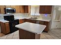 Kitchen with stainless steel appliances, wood cabinetry, and a center island at 17458 N 64Th Dr, Glendale, AZ 85308