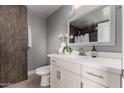 Bright bathroom featuring a vanity with white countertop, framed mirror, and gray walls at 1747 W Devon --, Mesa, AZ 85201
