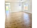 Open dining room area with light wood flooring and modern chandelier at 2114 N 94Th Ave, Phoenix, AZ 85037