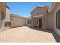 Private front courtyard with an outdoor fireplace, brick paving, and a charming entrance at 2859 E Los Altos Rd, Gilbert, AZ 85297