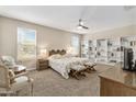 Spacious main bedroom with ample natural light, a ceiling fan, carpeted flooring, and a built-in bookshelf at 36130 N Quiros Dr, Queen Creek, AZ 85143