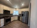 Modern kitchen featuring stainless steel appliances, white cabinets, granite countertops, and gray backsplash at 3935 E Rough Rider Rd # 1282, Phoenix, AZ 85050