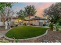 Charming single-story house with a well-manicured lawn, mature trees, and a walkway at 3955 E Fox Cir, Mesa, AZ 85205