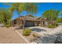 A single-story home featuring desert landscaping with a two-car garage and a well-kept lawn at 4241 E Bonanza Rd, Gilbert, AZ 85297