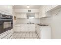 Well-lit kitchen with white cabinets, tile flooring, and appliances at 4553 N 54Th Ave, Phoenix, AZ 85031