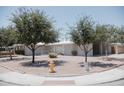 Charming single-story home with desert landscaping, a yellow fire hydrant, and mature shade trees at 5602 W Heatherbrae Dr, Phoenix, AZ 85031