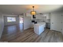 A bright kitchen features a kitchen island, wood flooring, white cabinets and stainless steel appliances at 5951 W Granada Rd, Phoenix, AZ 85035