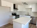 Bright kitchen with a kitchen island, stainless steel appliances, and white cabinets at 5951 W Granada Rd, Phoenix, AZ 85035