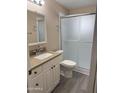 Bathroom with updated vanity, granite counters and a walk-in shower with glass doors at 6048 E Des Moines St, Mesa, AZ 85205