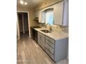 Updated kitchen features stainless steel appliances, wood-look floors, and a window over the sink at 6048 E Des Moines St, Mesa, AZ 85205