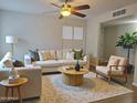 Bright living room featuring a ceiling fan, large windows, and stylish furniture at 761 W Gail Dr, Chandler, AZ 85225
