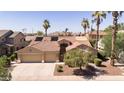 Inviting beige home with terracotta roof, two-car garage, desert landscaping, and solar panels at 786 E Coconino Dr, Chandler, AZ 85249