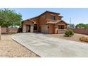Gorgeous two-story house boasting a xeriscaped front yard, a concrete driveway, and terracotta exterior at 833 S 113Th Ave, Avondale, AZ 85323