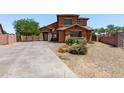 Charming two-story home featuring a xeriscaped front yard and a long concrete driveway at 833 S 113Th Ave, Avondale, AZ 85323