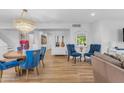 Bright open-concept living room with a chandelier, stylish blue chairs, and hardwood flooring at 908 E State Ave, Phoenix, AZ 85020