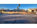 Street view of a gray single-story home with a new horizontal wood slat fence at 11014 W Cocopah St, Avondale, AZ 85323