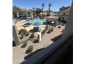 View of community pool with water feature, chairs, tables and shade, from a balcony at 11375 E Sahuaro Dr # 2033, Scottsdale, AZ 85259