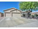 Well maintained traditional single-story home with a large driveway, desert landscaping, and a two car garage at 11580 N 86Th Ln, Peoria, AZ 85345
