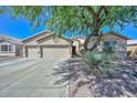 Traditional home featuring a well-kept lawn, mature trees, and a convenient two-car garage at 11580 N 86Th Ln, Peoria, AZ 85345