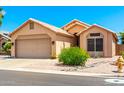 Charming single-story home with a desert landscape, tile roof, and a two-car garage at 11631 W Lemon Ct, Surprise, AZ 85378