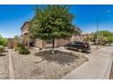 Charming two-story home showcases desert landscaping and a mature shade tree at 15006 N 172Nd Ln, Surprise, AZ 85388