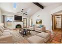 Bright living room featuring a brick fireplace, two skylights, beamed ceiling, and tiled flooring at 16648 N 30Th Ave, Phoenix, AZ 85053