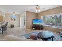 Open-concept living room featuring tile floors, ceiling fans, and seamless access to the kitchen at 20234 N Mariposa Way, Surprise, AZ 85374