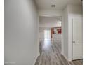 Inviting hallway with modern wood-look flooring that leads to open-concept living space at 20410 N Mac Neil St, Maricopa, AZ 85138