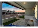 Relaxing covered front porch overlooking the street with low white brick wall and some artificial turf at 2929 E Broadway Rd # 50, Mesa, AZ 85204