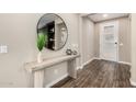Elegant entryway featuring wood flooring, a console table, and a decorative round mirror at 3338 E Coconino Dr, Gilbert, AZ 85298